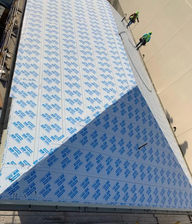 Professional roofers installing underlayment on a metal roof in Neptune Beach